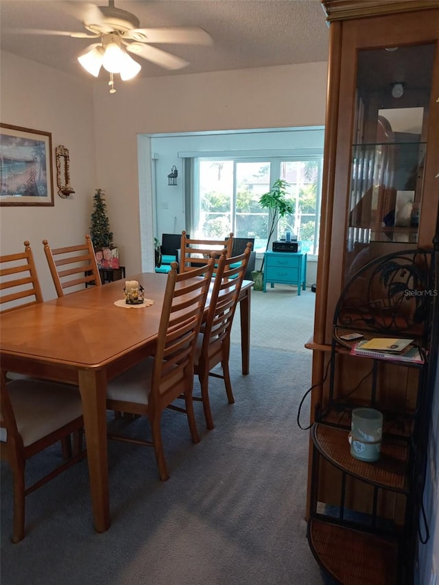 dining area featuring carpet, a textured ceiling, and ceiling fan