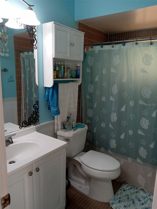 full bathroom featuring tile patterned flooring, vanity, toilet, and shower / bath combo with shower curtain