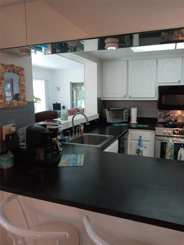 kitchen with white cabinets, white appliances, backsplash, and sink