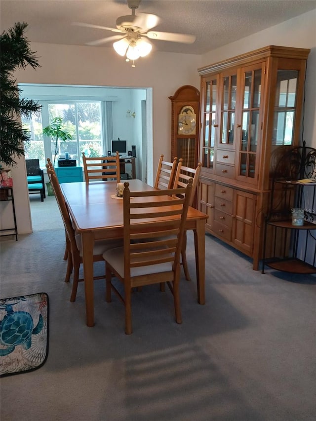 dining area featuring carpet, a textured ceiling, and ceiling fan