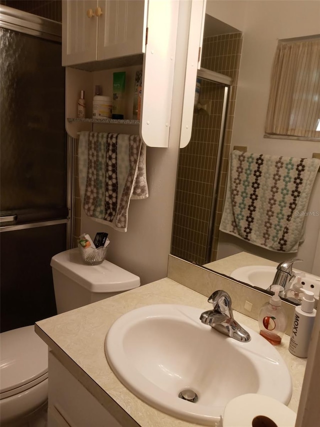 bathroom with vanity, toilet, and walk in shower