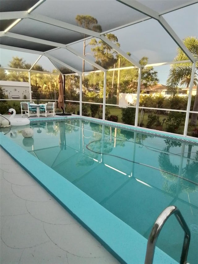 pool at dusk featuring a lanai