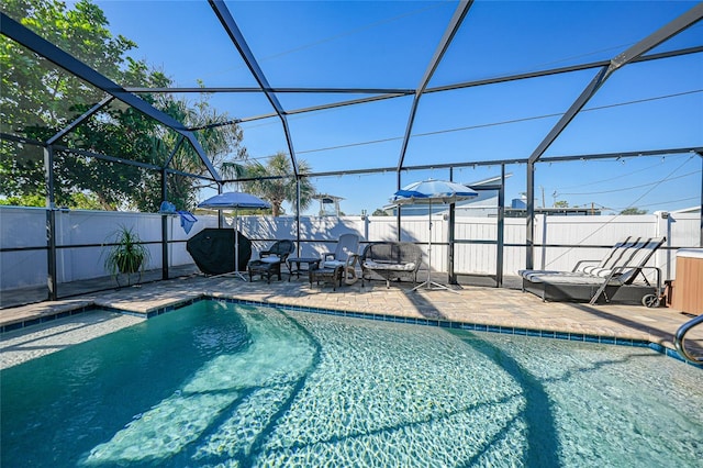 view of swimming pool featuring glass enclosure and a patio