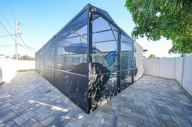 view of side of property featuring a patio area and a lanai