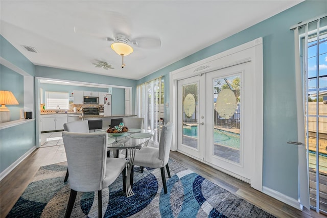 dining area featuring ceiling fan, french doors, a healthy amount of sunlight, and light hardwood / wood-style flooring