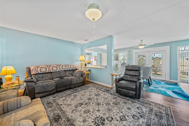 living room featuring ceiling fan, hardwood / wood-style floors, and french doors