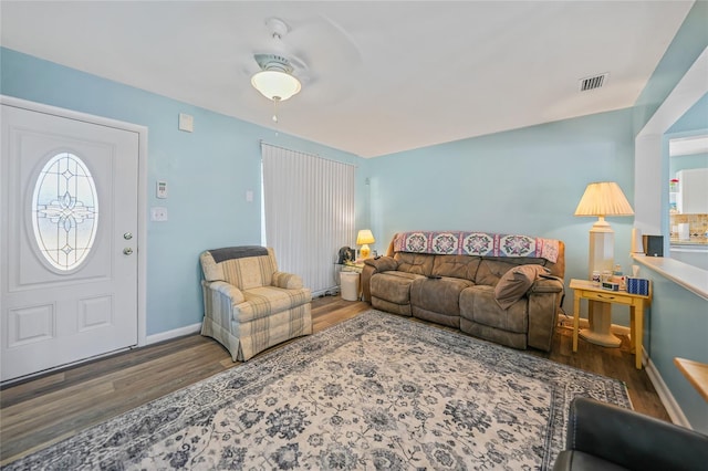 living room with ceiling fan and dark wood-type flooring