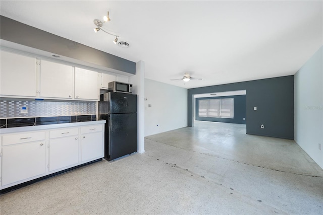 kitchen with black refrigerator, backsplash, ceiling fan, white cabinets, and tile counters