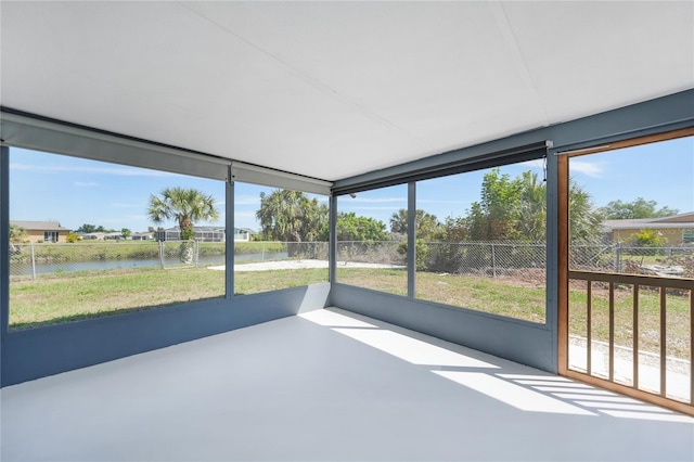 unfurnished sunroom featuring a water view