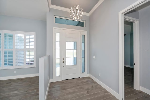 entrance foyer featuring hardwood / wood-style flooring, ornamental molding, and a notable chandelier