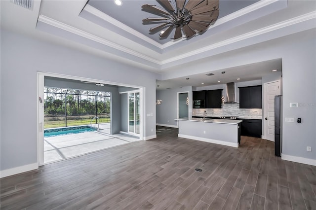 unfurnished living room with dark hardwood / wood-style flooring, a raised ceiling, crown molding, and sink