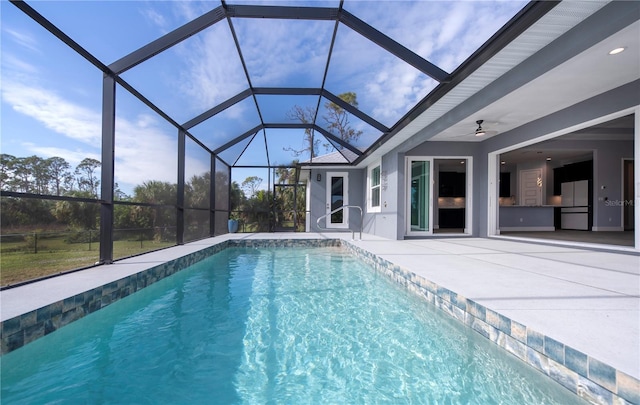 view of pool with a lanai, ceiling fan, and a patio