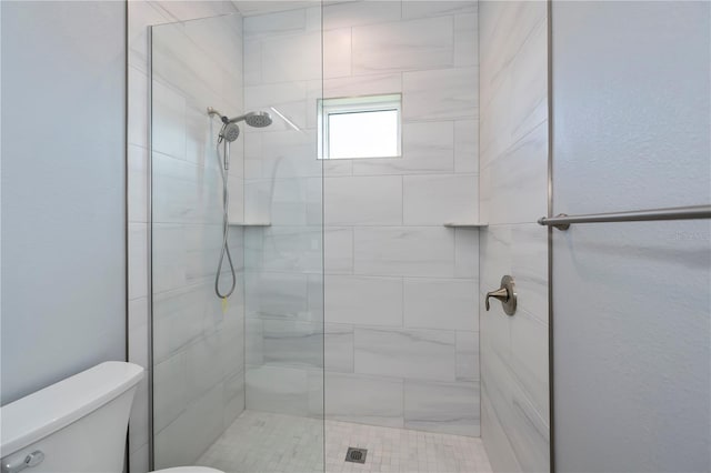 bathroom featuring toilet and tiled shower