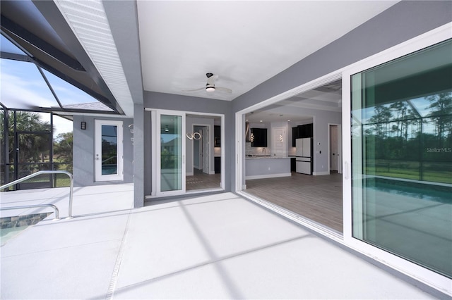 view of patio / terrace with ceiling fan and a lanai