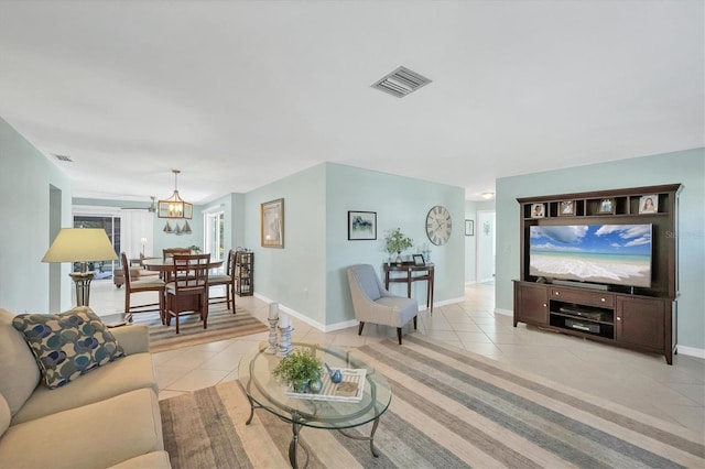 tiled living room with a notable chandelier