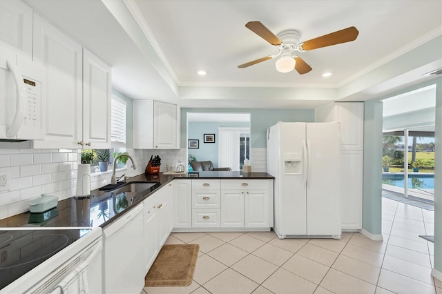 kitchen featuring decorative backsplash, white appliances, sink, light tile patterned floors, and white cabinets