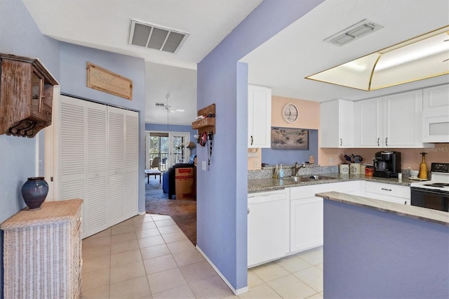 kitchen featuring light tile patterned flooring, white appliances, white cabinetry, and sink