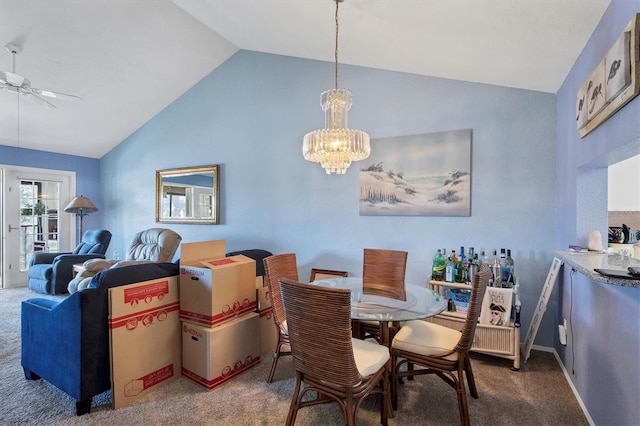 carpeted dining space featuring ceiling fan with notable chandelier and lofted ceiling