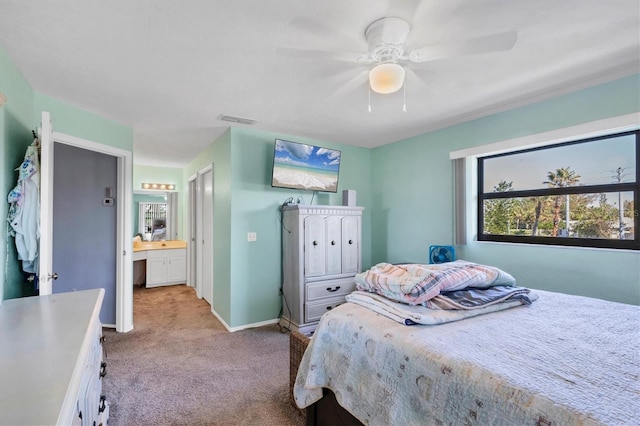 bedroom featuring ensuite bathroom, ceiling fan, and light colored carpet