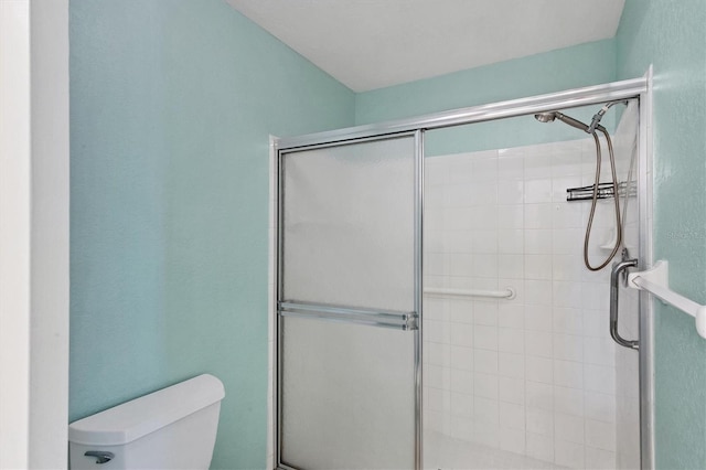 bathroom featuring an enclosed shower and toilet