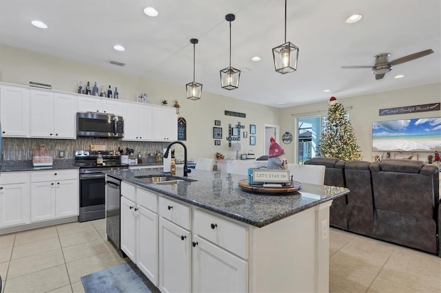 kitchen featuring a kitchen island with sink, sink, ceiling fan, and stainless steel appliances