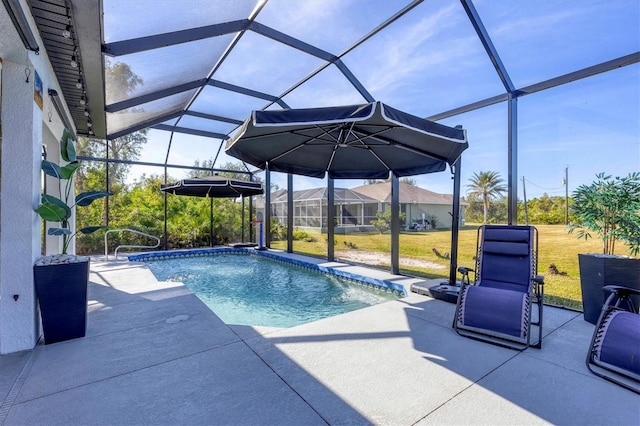 view of swimming pool featuring a lanai, a patio area, and a lawn