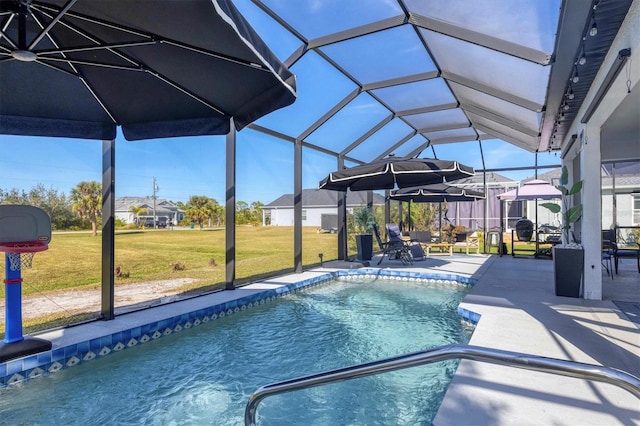 view of swimming pool with a yard, glass enclosure, and a patio area