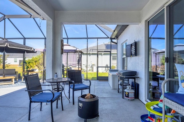 view of patio featuring glass enclosure, a grill, and a fire pit