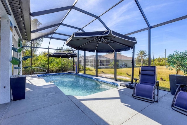 pool with glass enclosure, a yard, and a patio area