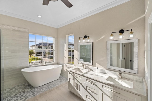 bathroom featuring ceiling fan, a tub to relax in, crown molding, wood-type flooring, and vanity