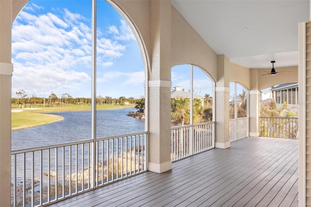 wooden terrace featuring ceiling fan and a water view