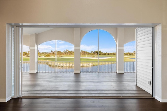 doorway with a water view and dark hardwood / wood-style floors