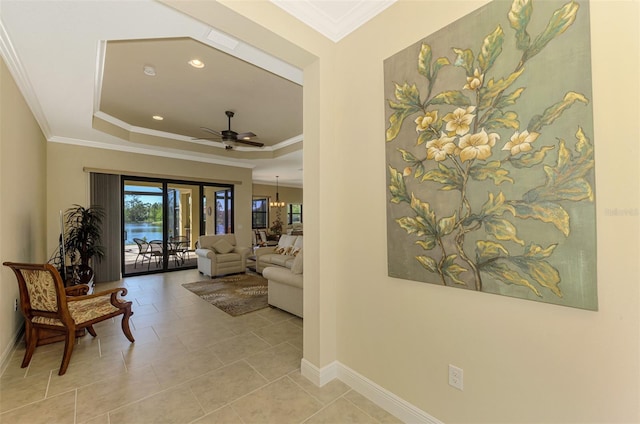 hallway with french doors, light tile patterned floors, a raised ceiling, and crown molding