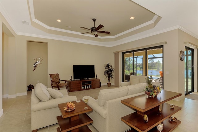 tiled living room featuring a raised ceiling, ceiling fan, and ornamental molding