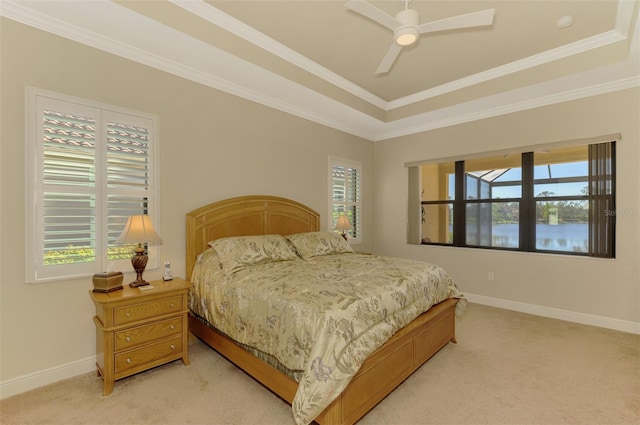 carpeted bedroom featuring ceiling fan, a raised ceiling, and crown molding