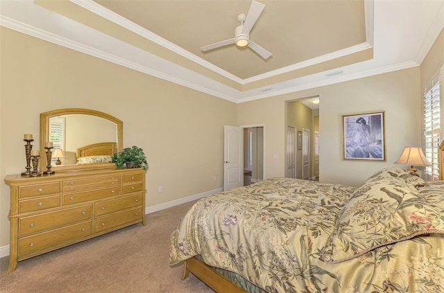 carpeted bedroom with a raised ceiling, ceiling fan, and crown molding