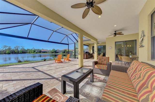 view of patio with a lanai, ceiling fan, a water view, and an outdoor living space