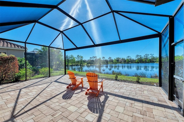 view of patio featuring a lanai and a water view