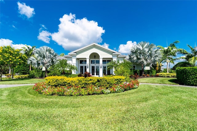 view of front of home with a balcony and a front lawn