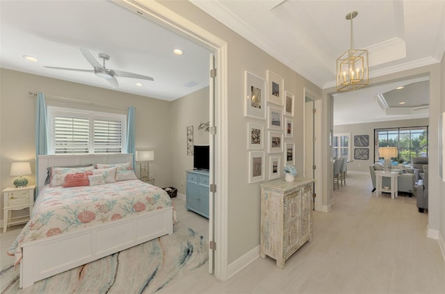 bedroom with a tray ceiling, crown molding, and ceiling fan with notable chandelier