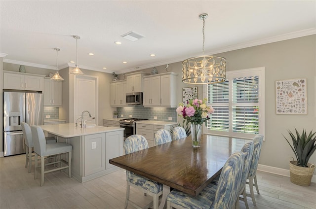 dining space with light hardwood / wood-style flooring and crown molding