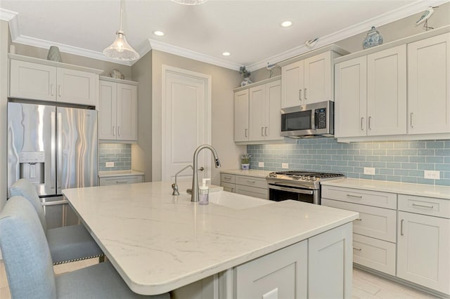 kitchen featuring a center island with sink, sink, a breakfast bar area, and appliances with stainless steel finishes