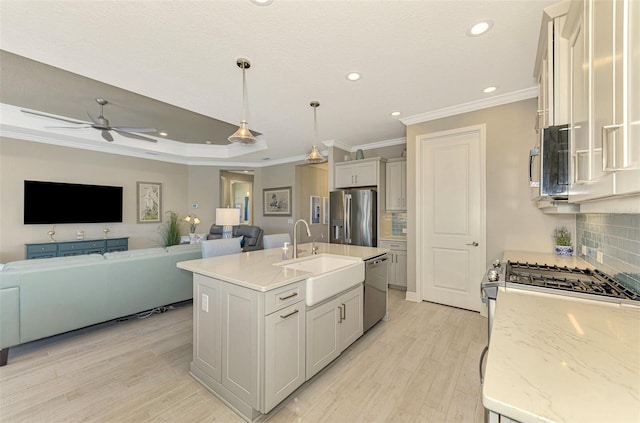 kitchen with sink, backsplash, decorative light fixtures, a center island with sink, and appliances with stainless steel finishes