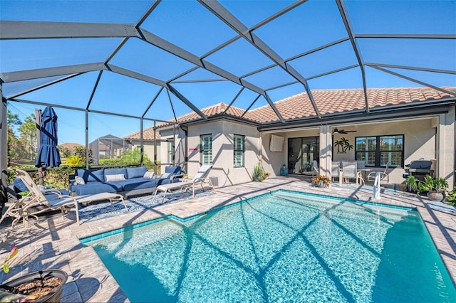 view of pool with glass enclosure, ceiling fan, and a patio