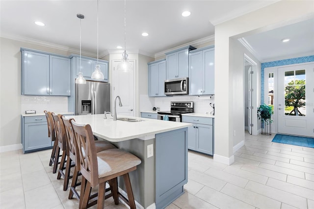 kitchen with sink, a breakfast bar area, hanging light fixtures, a kitchen island with sink, and stainless steel appliances