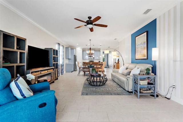 tiled living room featuring ornamental molding and ceiling fan with notable chandelier