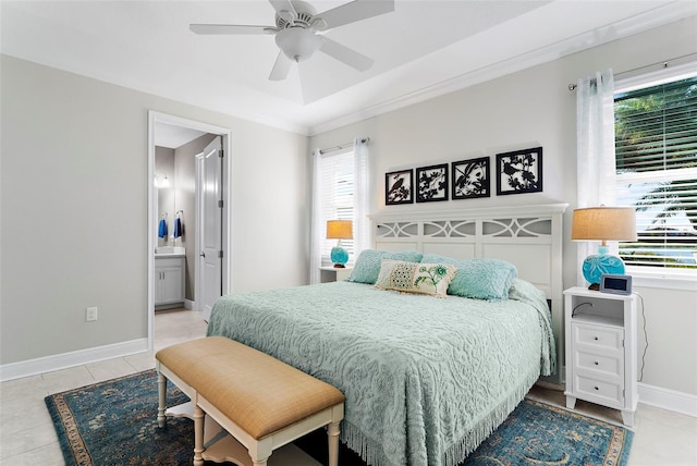 tiled bedroom with ceiling fan, ensuite bathroom, and a tray ceiling