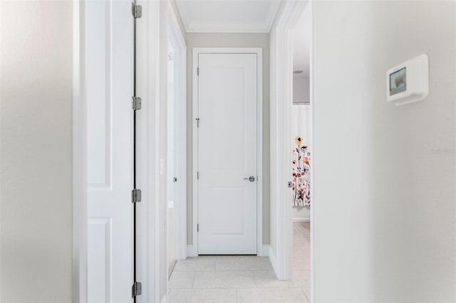 corridor featuring crown molding and light tile patterned floors