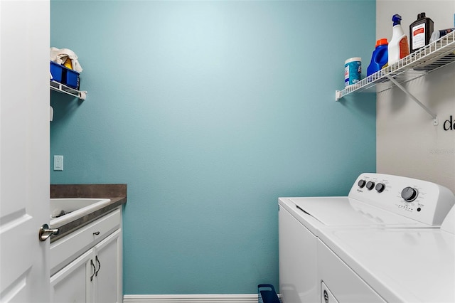 laundry room featuring cabinets, washer and dryer, and sink