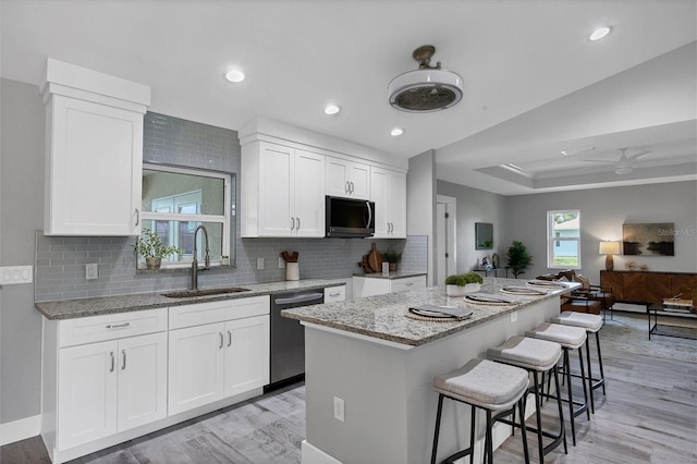 kitchen featuring a center island, sink, light hardwood / wood-style flooring, white cabinetry, and stainless steel appliances